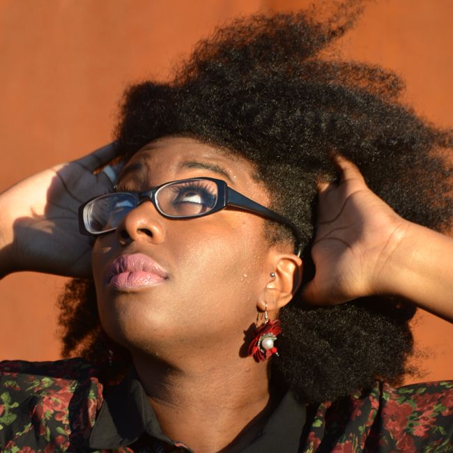 Editor April B runs her hands through a thick twistout and looks at the sky questioningly.