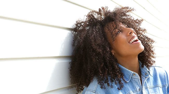 Beautiful young woman laughing outdoors by m-imagephotography