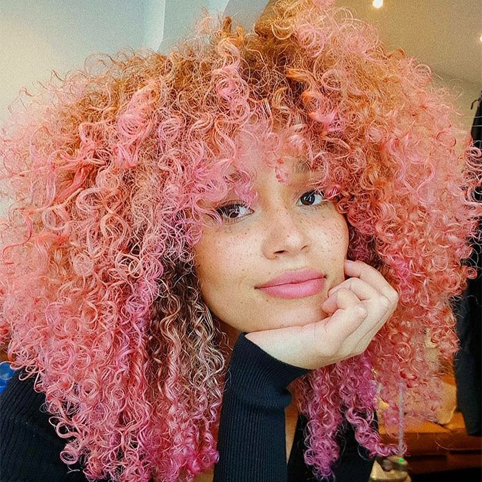 Woman with curly hair of multi colorful pink shades