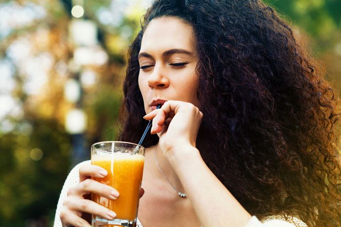 curly woman drinking juice