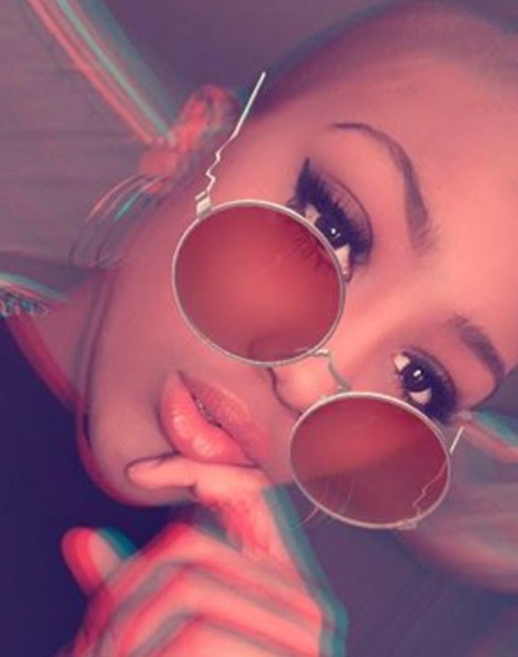 Lulu wearing round sunglasses and smoky makeup with a filter that distorts the image in the style of looking at a flat picture with 3d glasses