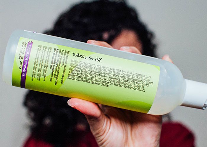 Woman holding bottle of gel to show ingredients