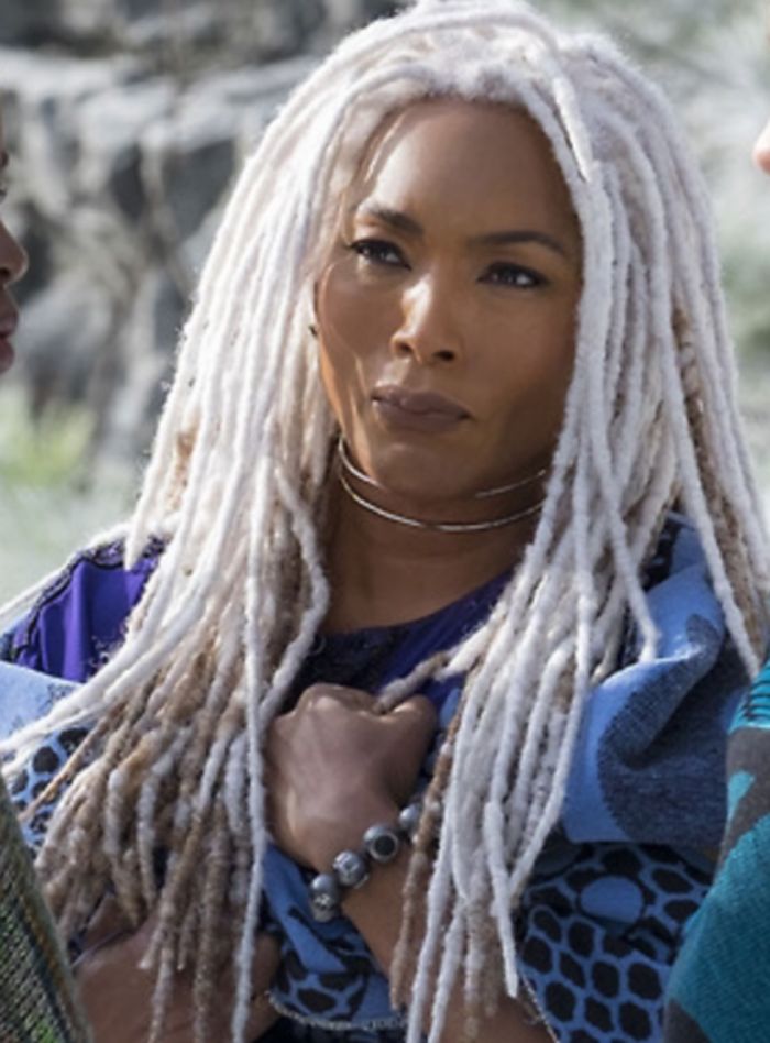 Angela Bassett, a black woman, as Queen Ramonda stands in silver locs