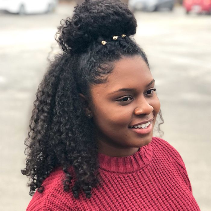 African-American woman with curly hair wearing a red sweater