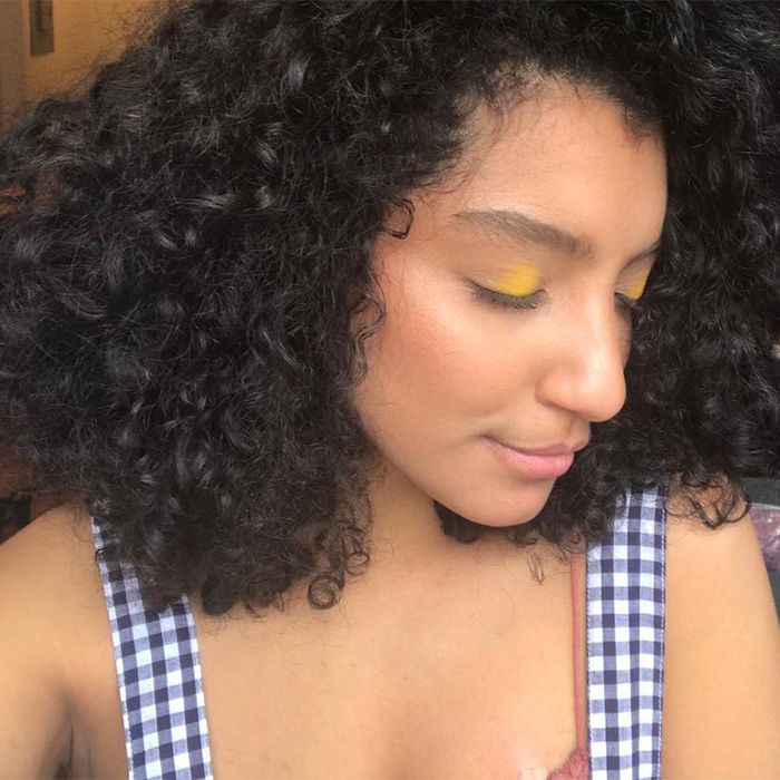 Woman with curly hair wearing yellow eyeshadow