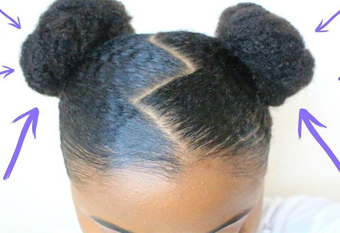 African-American women with zig zag part and two buns looking down