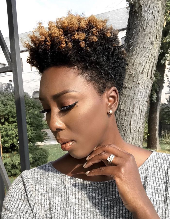 African-American woman with short tapered curly cut looking down