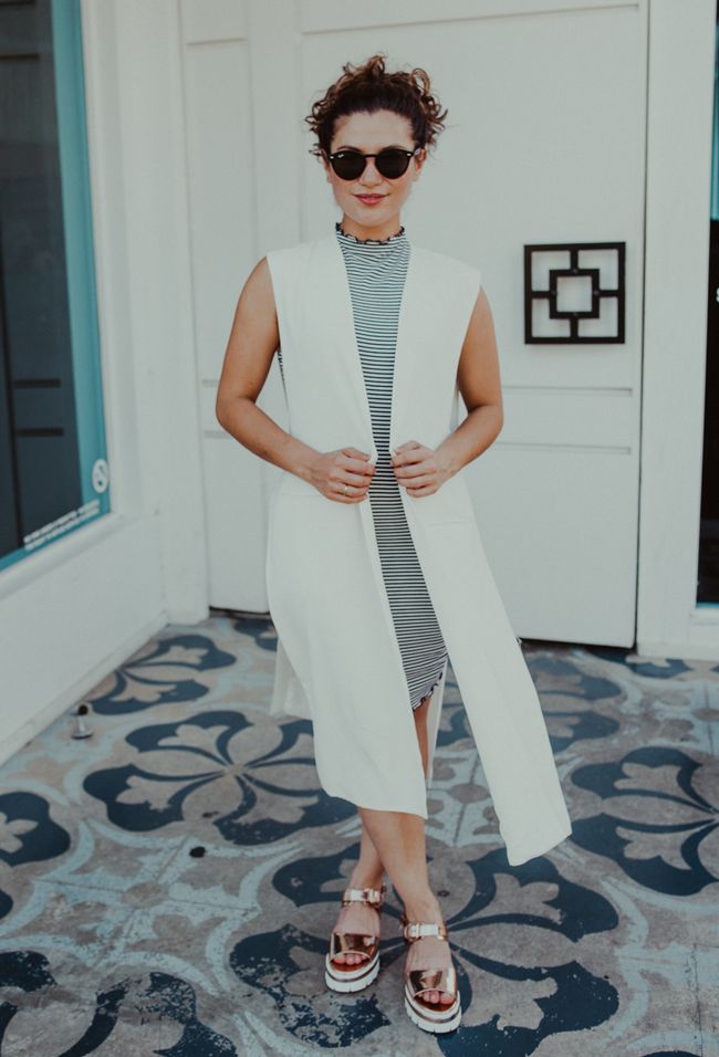 street style shot of white duster jacket, striped dress, platform sandals