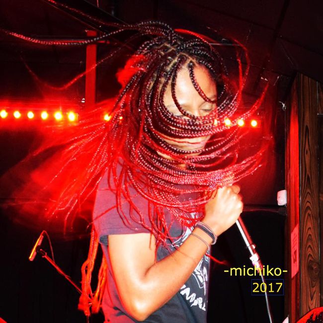 gerilyn performing in sugarpill Gerilyn on stage whipping red and black braids around with her band Sugarpill.