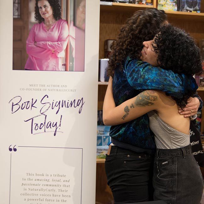 Author Michelle Breyer embraces book signing attendee at event.