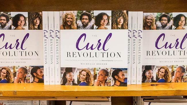 Copies of The Curl Revolution by Michelle Breyer sit on retail shelves at BookPeople in Austin, TX.